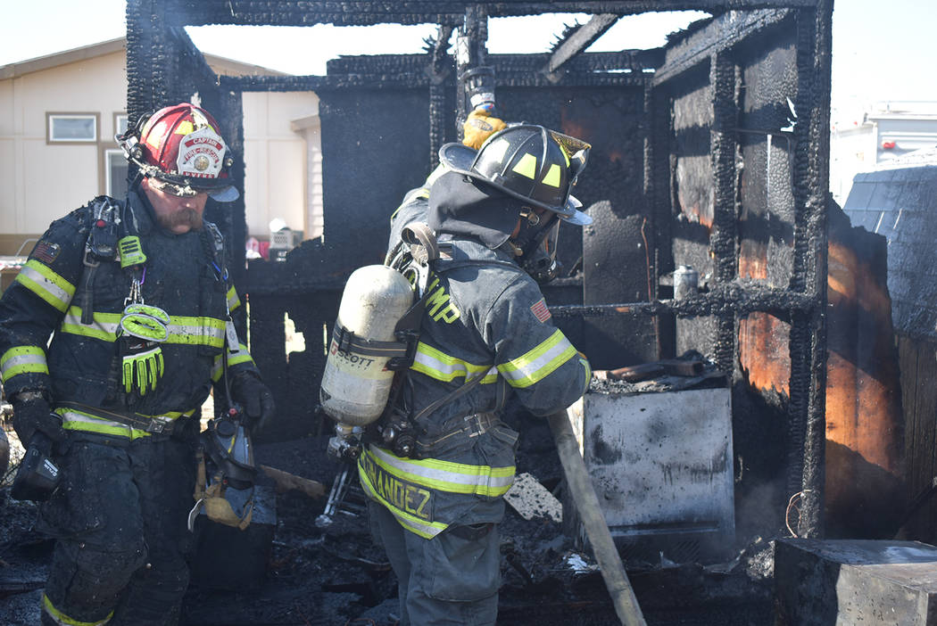 Special to the Pahrump Valley Times Pahrump firefighters inspect the remains of two sheds destr ...