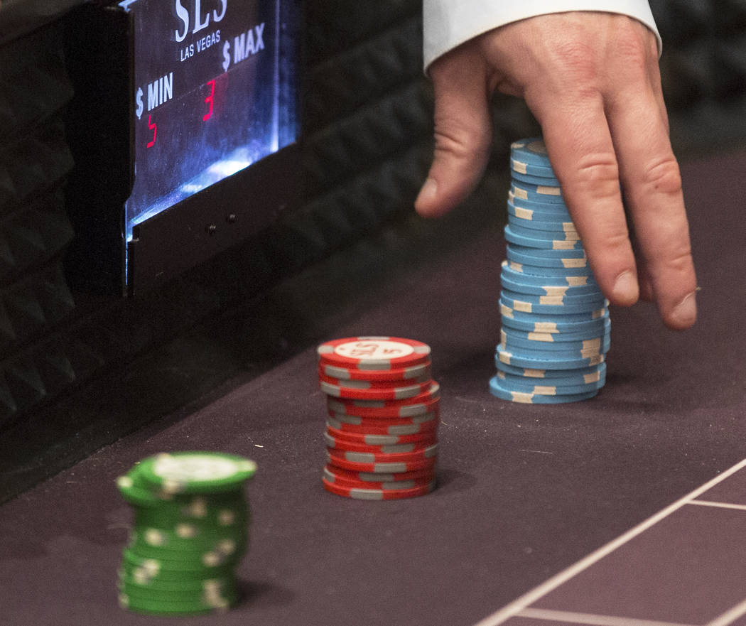 A dealer moves a stack of chips on the craps table at SLS Las Vegas on Thursday, May, 30, 2019, ...