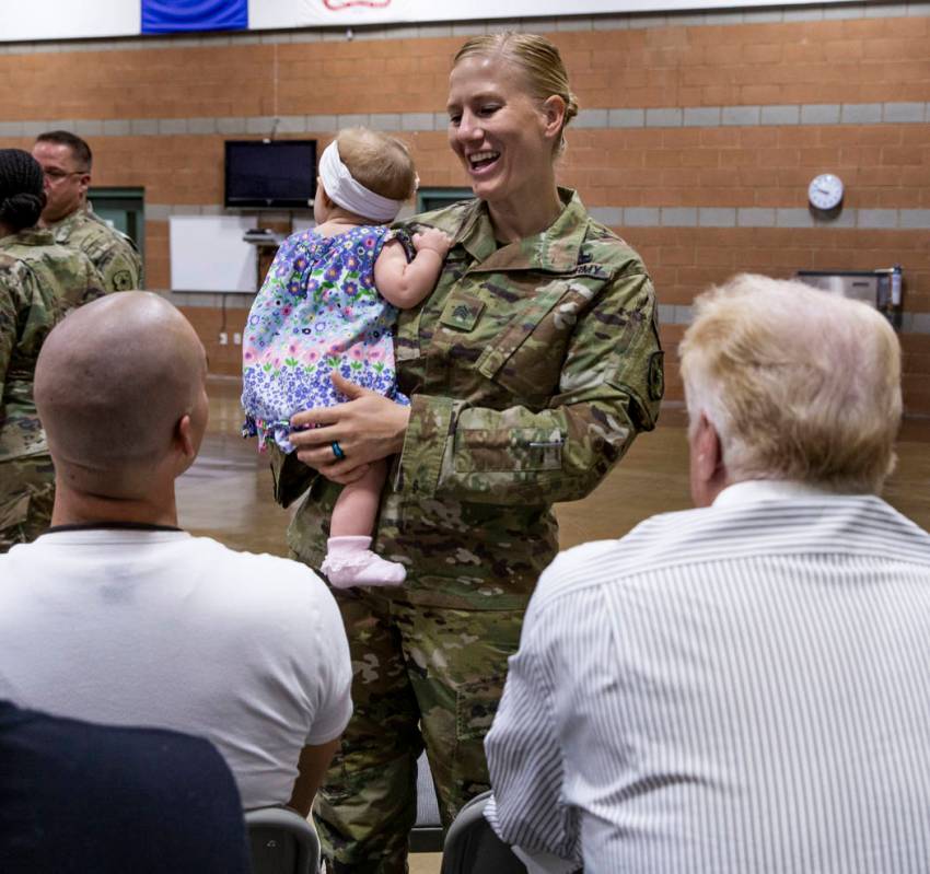 Sgt. Jessica Done holds her daughter Rylie, 8-month-old, as she talks with family before a mobi ...