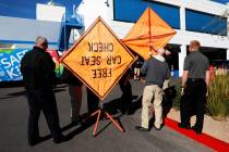Nevada Highway Patrol troopers assemble a couple of signs to place on the corner of the car lot ...