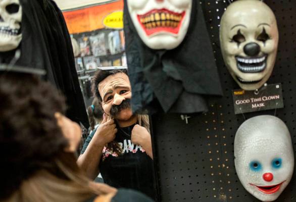 Ellen Schmidt/Las Vegas Review-Journal Laura Silva of St. George, Utah tries on a mask for her ...