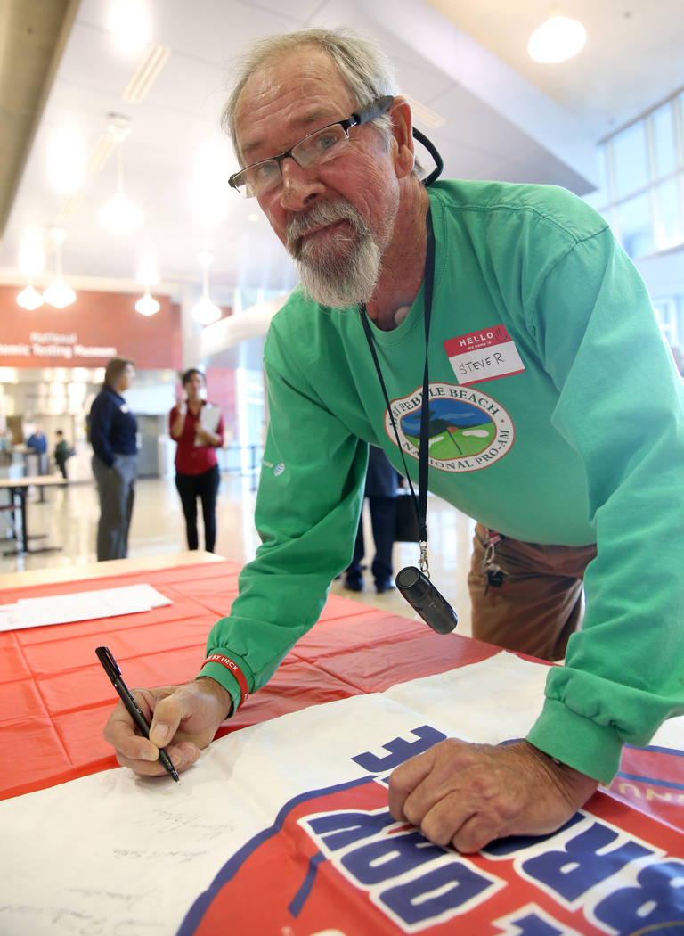 Steve Radley, 73, of Pahrump signs a banner during the Cold War Patriots National Day of Rememb ...