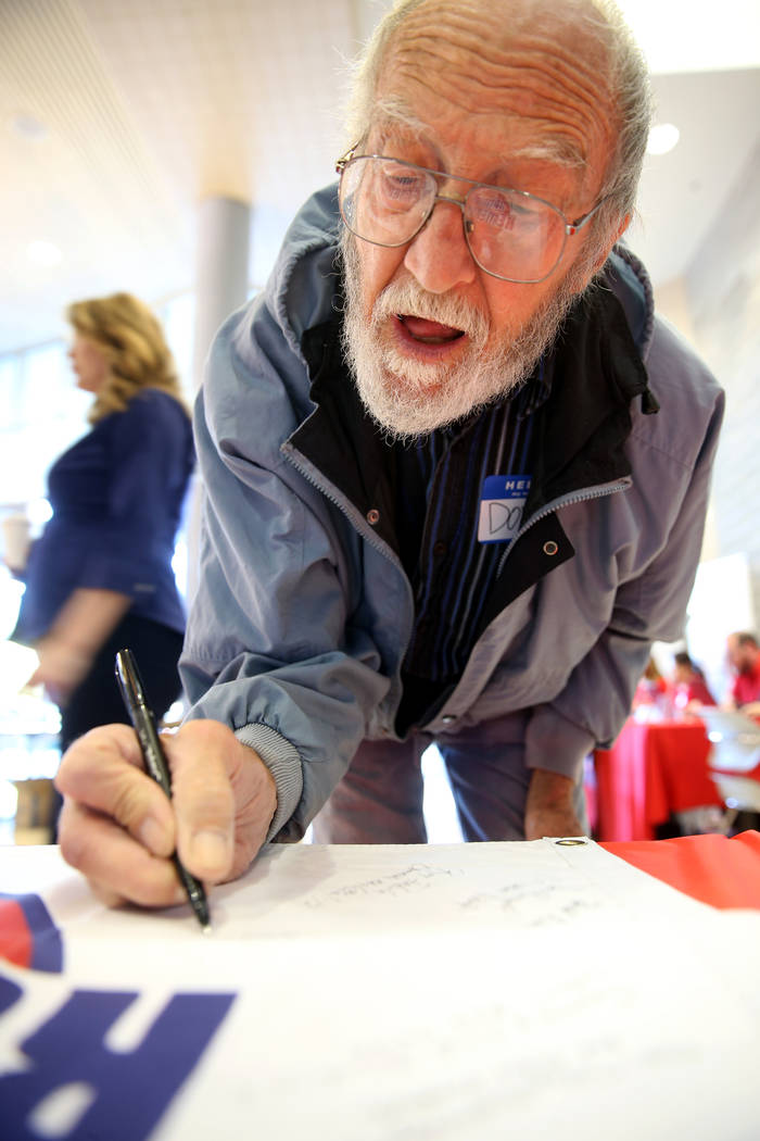 Donald Miller, 79, of Las Vegas signs a banner during the Cold War Patriots National Day of Rem ...