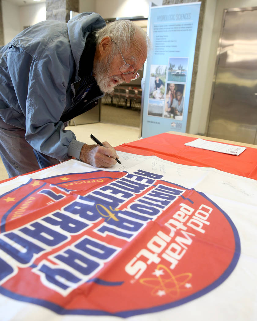 Donald Miller, 79, of Las Vegas signs a banner during the Cold War Patriots National Day of Rem ...