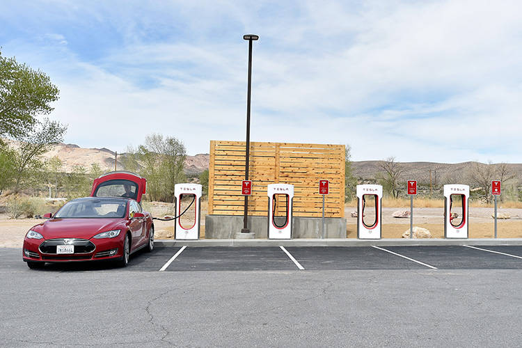 A Tesla electric car is seen charging before the dedication first electric car charging station ...