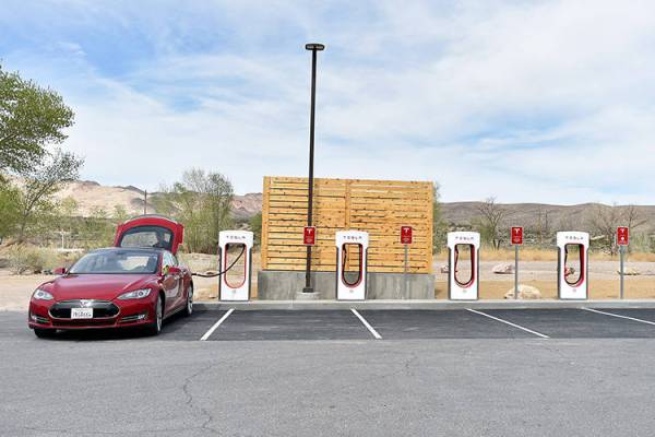 A Tesla electric car is seen charging before the dedication first electric car charging station ...