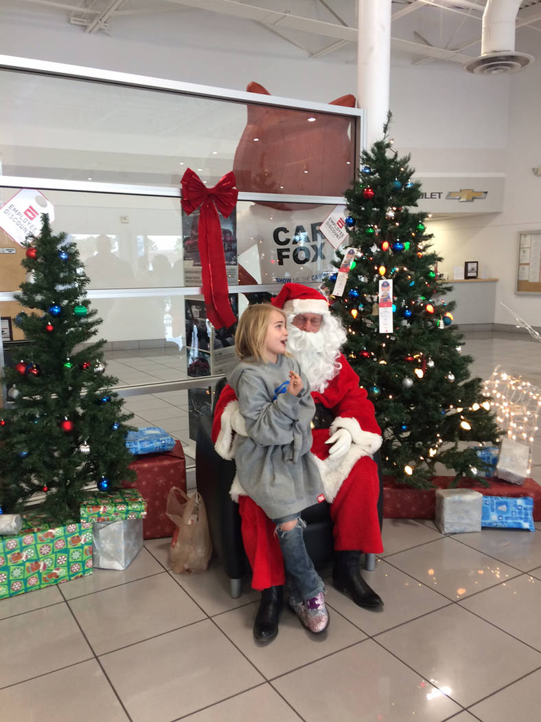 Robin Hebrock/Pahrump Valley Times A valley child sits down on Santa's lap and imparts her Chri ...