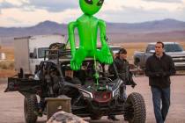 Festivalgoers arrive by all-terrain vehicle with an alien strapped to the top in front of the L ...