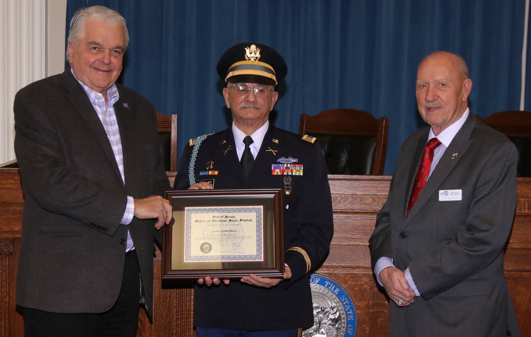 Steve Ranson/Nevada News Group Gov. Steve Sisolak, left, presents the December Veteran of the M ...