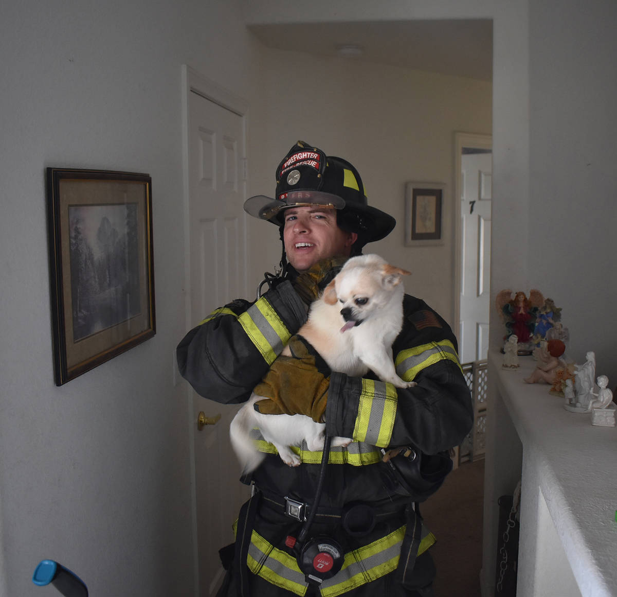Special to the Pahrump Valley Times A Pahrump firefighter rescues the family dog after crews ex ...