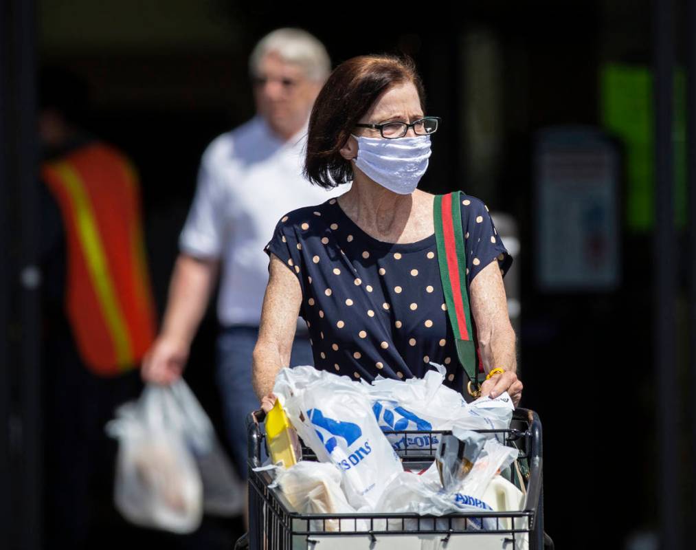 Benjamin Hager/Las Vegas Review-Journal Shoppers wear protective masks as they leave Albertsons ...