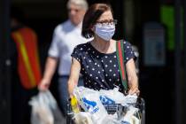 Benjamin Hager/Las Vegas Review-Journal Shoppers wear protective masks as they leave Albertsons ...