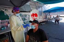 Nurse Tanya Markos administers a coronavirus test on patient Juan Ozoria at a mobile COVID-19 t ...
