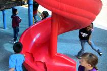Students run around a broken slide in the playground at Helen Smith Elementary School in Las Ve ...
