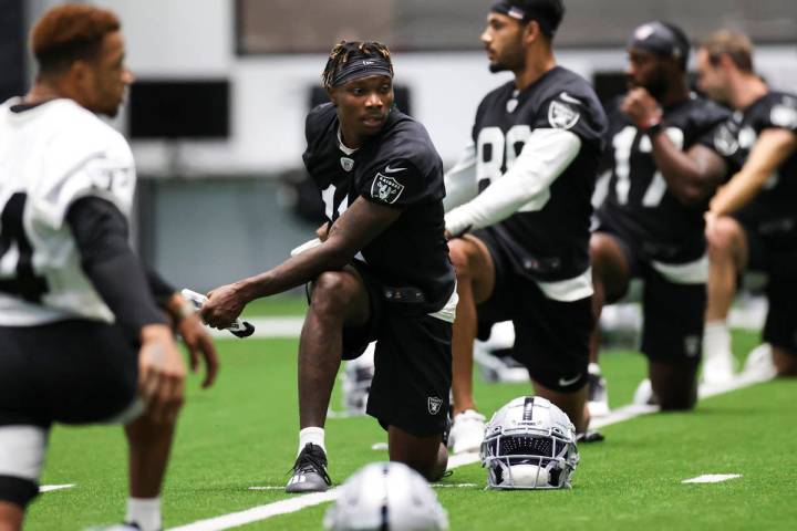Las Vegas Raiders wide receiver Henry Ruggs III (11) stretches with teammates during an NFL tra ...