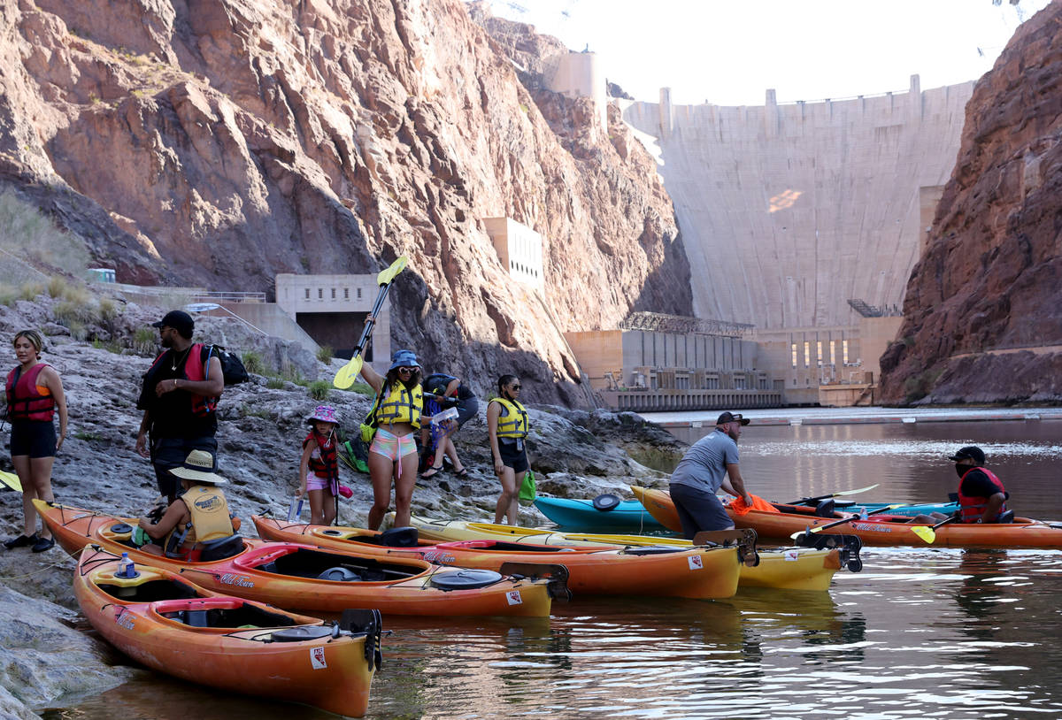 People prepare for a day of kayaking in Black Canyon at the base of the Hoover Dam with Desert ...