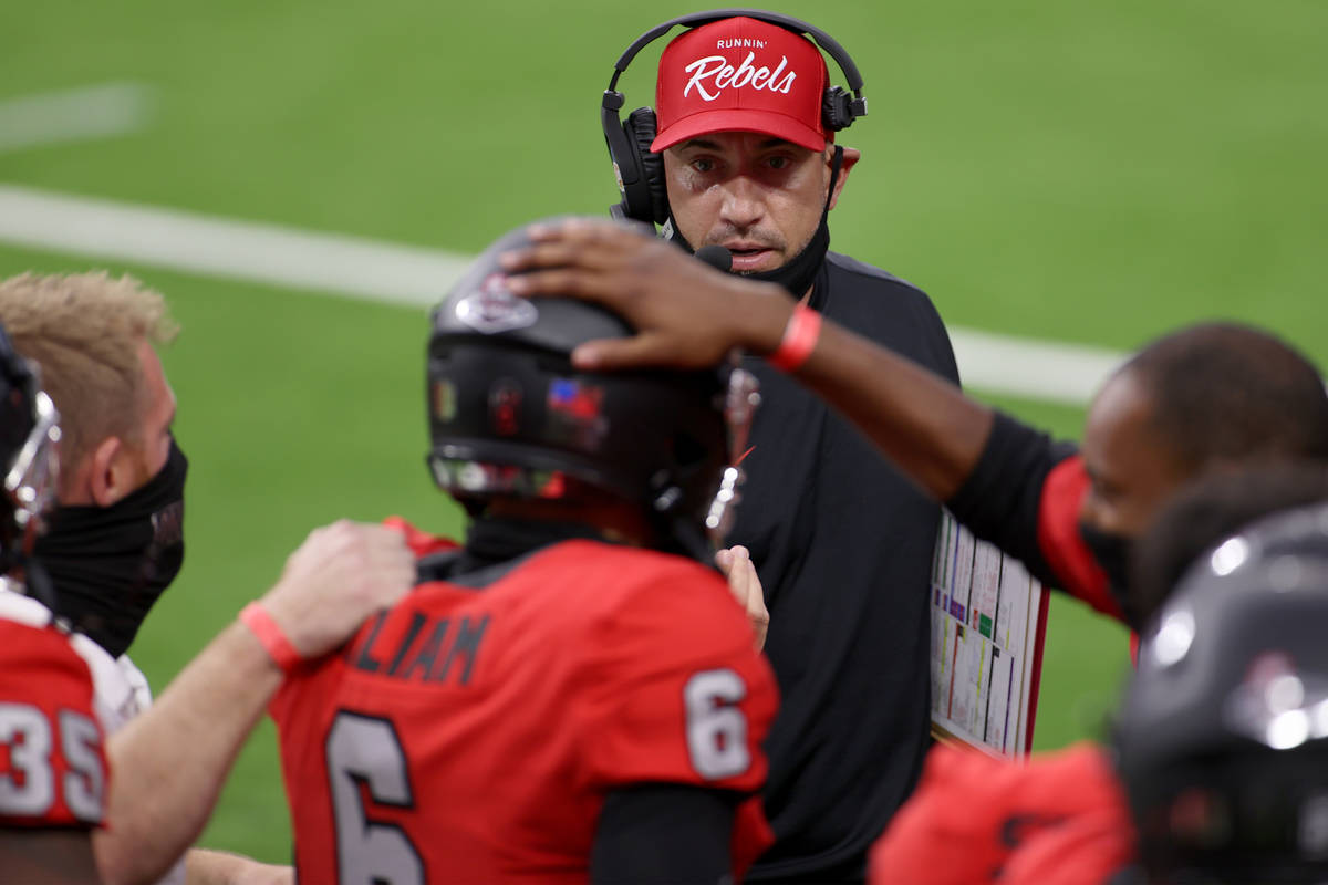 UNLV Rebels head coach Marcus Arroyo looks at quarterback Max Gilliam (6) after his rushing tou ...