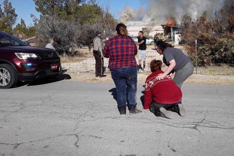Selwyn Harris/Pahrump Valley Times Amy Hewitt-Burton, center is comforted as she helplessly wat ...