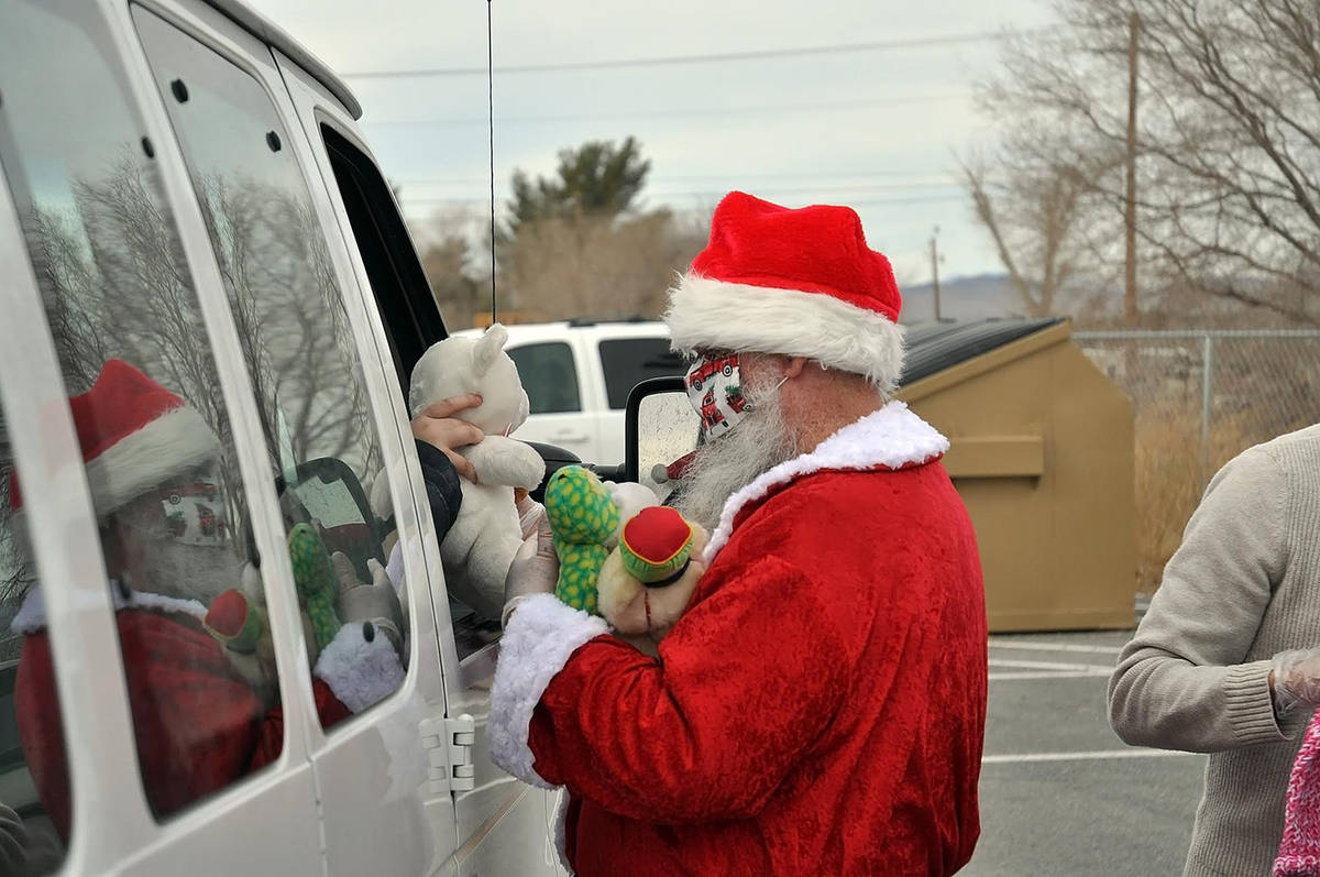 Horace Langford Jr./Pahrump Valley Times Santa Claus, seen with his hands stuffed full of toys, ...