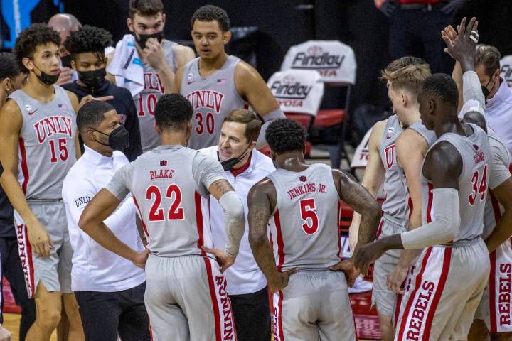 UNLV Rebels head coach T. J. Otzelberger counsels his players during a timeout versus the New M ...