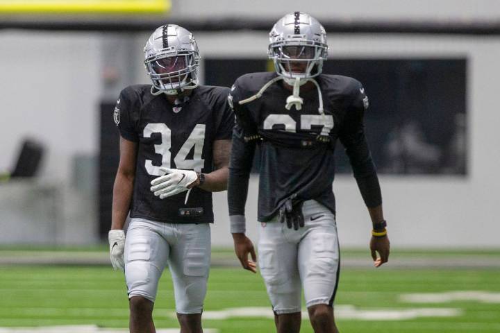 Las Vegas Raiders cornerback Kemah Siverand (34) warms up near cornerback Dylan Mabin (37) duri ...