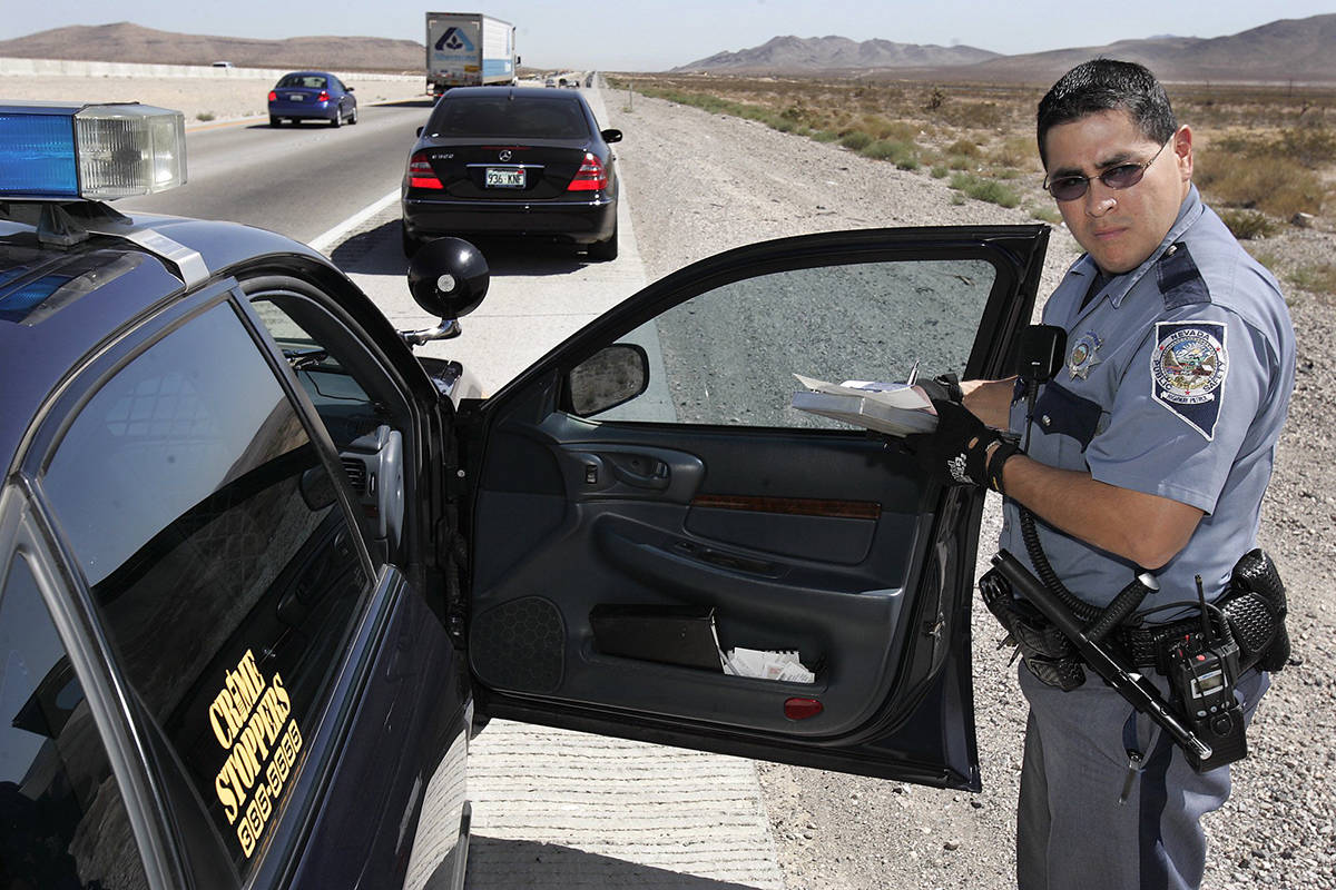 A Nevada Highway Patrol trooper writes a speeding ticket along I-15 south of Las Vegas in a 200 ...
