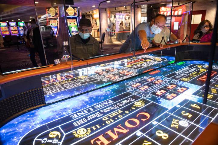 Rio Bencito of Los Angeles rolls dice on the new digital craps table, Rolls to Win Craps, at th ...