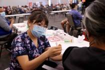 K.M. Cannon/Las Vegas Review-Journal Deanna Chea of UNLV Medicine gives a COVID-19 shot at the ...
