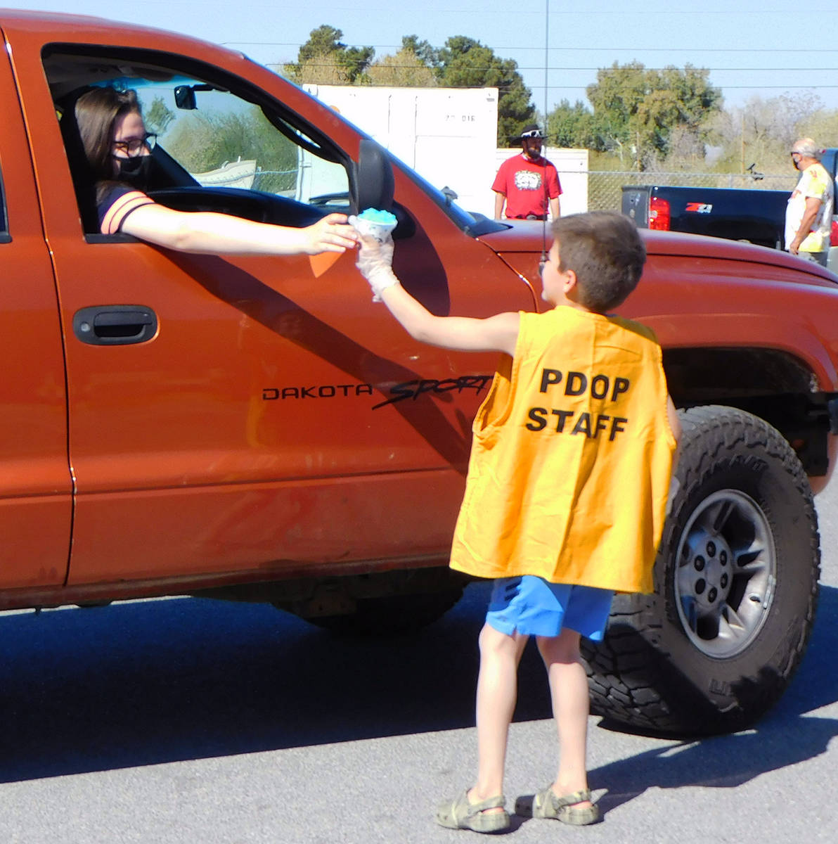 Robin Hebrock/Pahrump Valley Times A young PDOP volunteer is seen handing a snow cone to a Comm ...