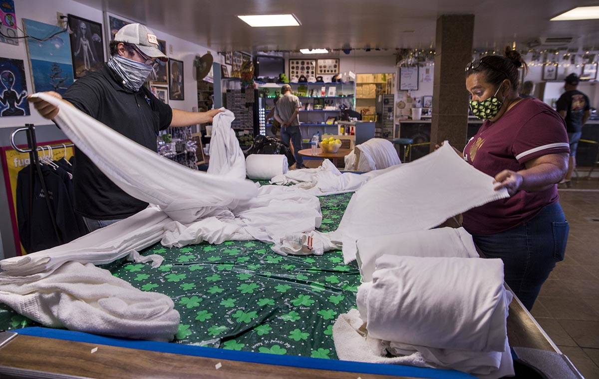 Connie West, right, and her son Cody Theising, fold bedding for their rooms at the Little A'Le' ...