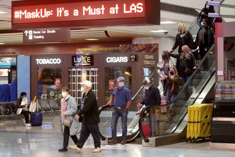 K.M. Cannon/Las Vegas Review-Journal Masked travelers walk through Terminal 1 at McCarran Inter ...
