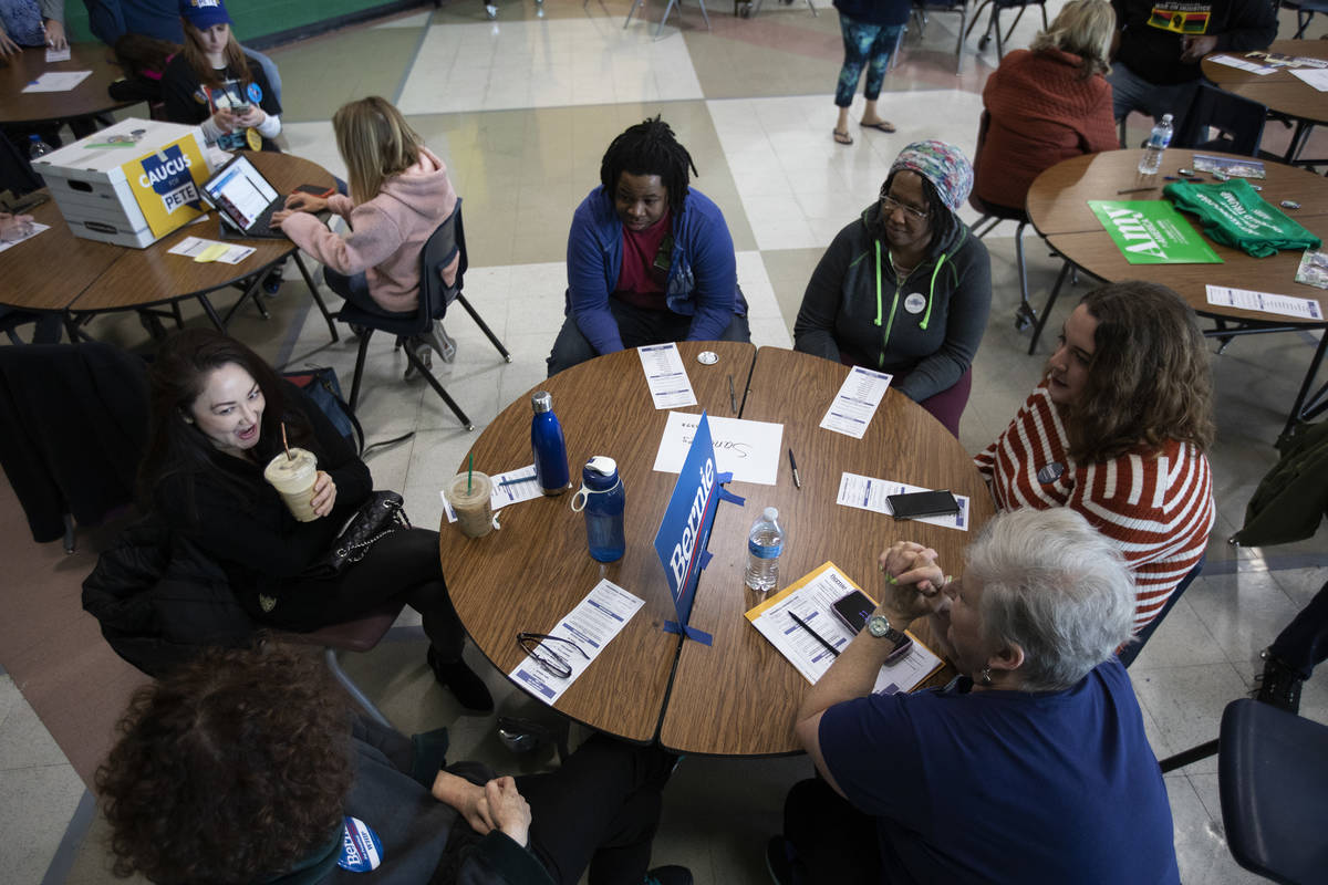Bernie Sanders supporters chat at their table before the Nevada caucus begins at Palo Verde Hig ...