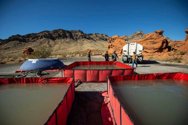 Water is prepared for transport by helicopter during an emergency water haul operation to reple ...