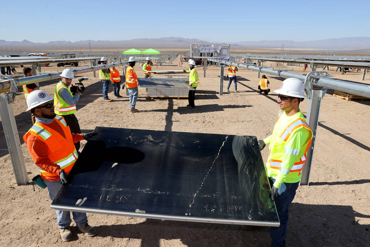 IBEW Local 357 workers, including Mark Contreras, left, and Chandler Higgins install modules at ...