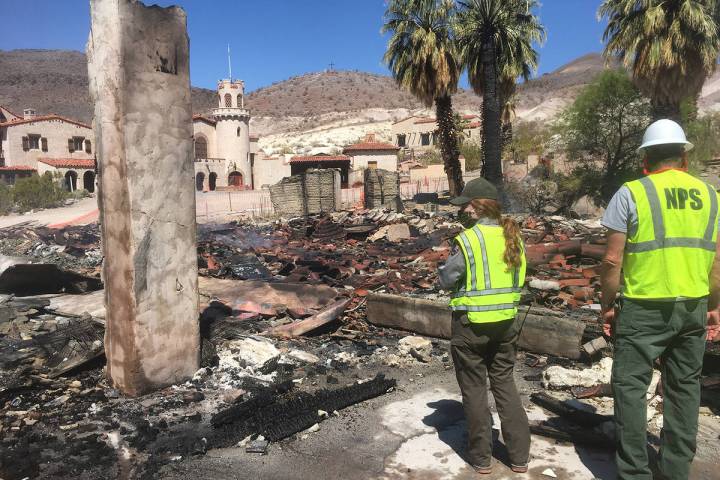 Death Valley National Park Rangers stand near the remnants of the historic garage in the Death ...