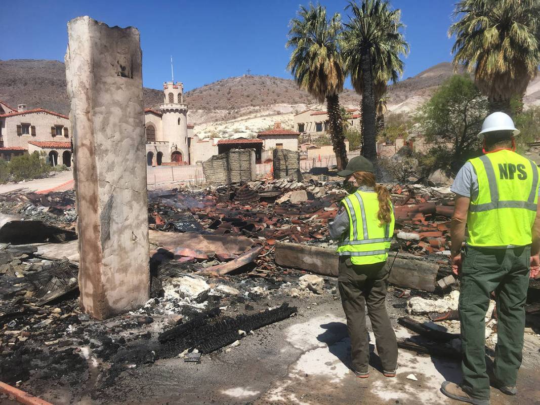 Death Valley National Park Rangers stand near the remnants of the historic garage in the Death ...