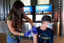 Tyler Straily, 14, receives his first dose of the Pfizer COVID-19 vaccination from nurse Alondr ...