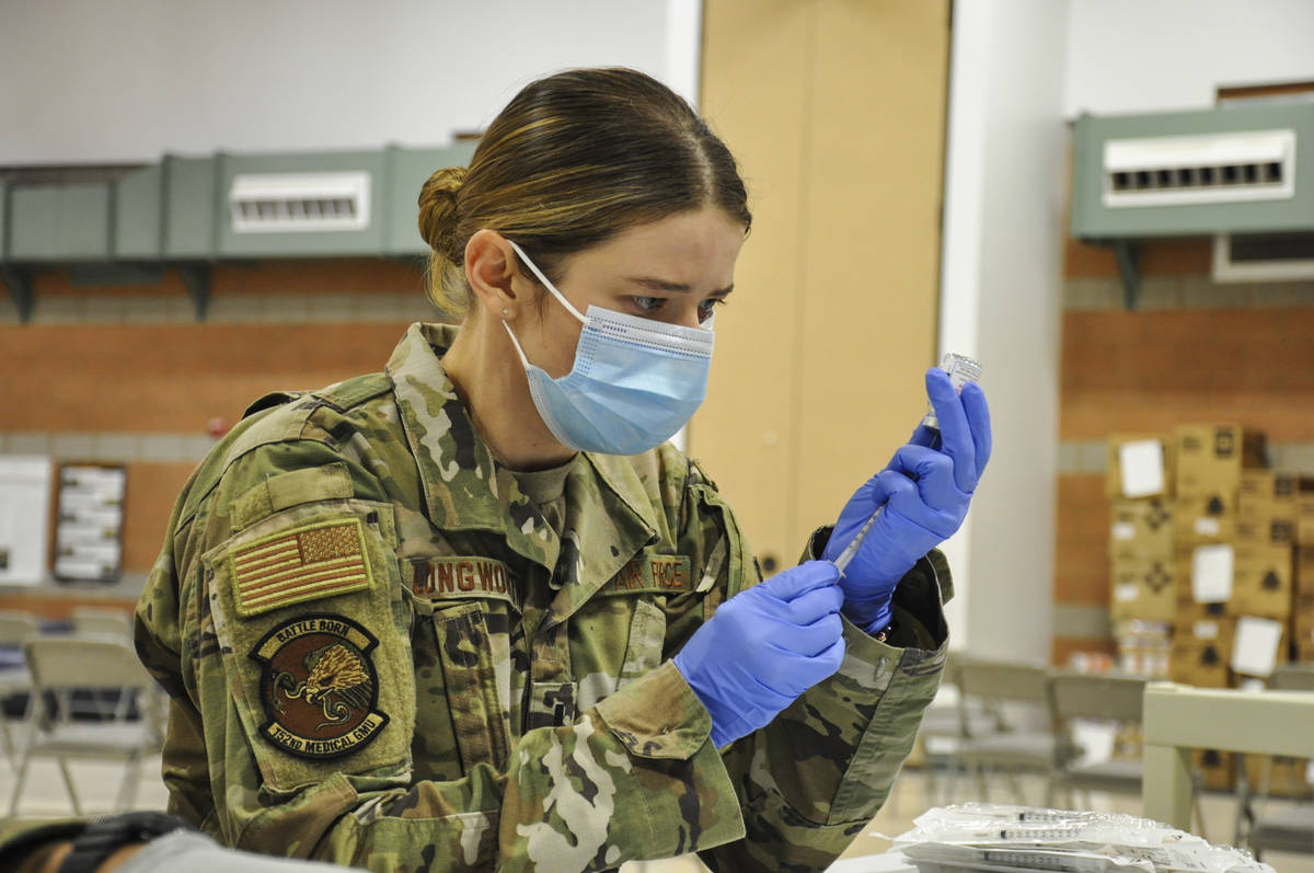 Caleena Longworth prepares a syringe with the Moderna vaccine at the Las Vegas Readiness Center ...