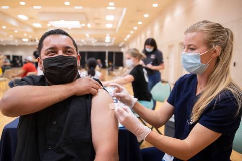 Jose Padilla, left, gets his COVID-19 vaccination from Touro University Nevada physician assist ...
