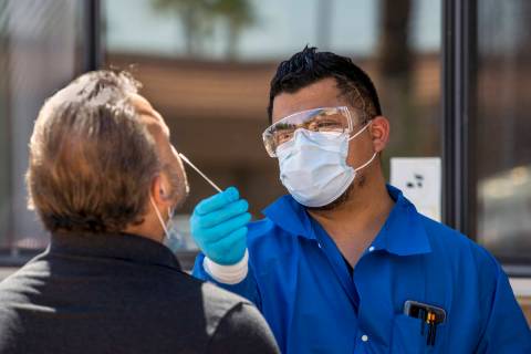 Jose Tirana conducts a COVID-19 test on a patient at Sahara West Urgent Care & Wellness on June ...