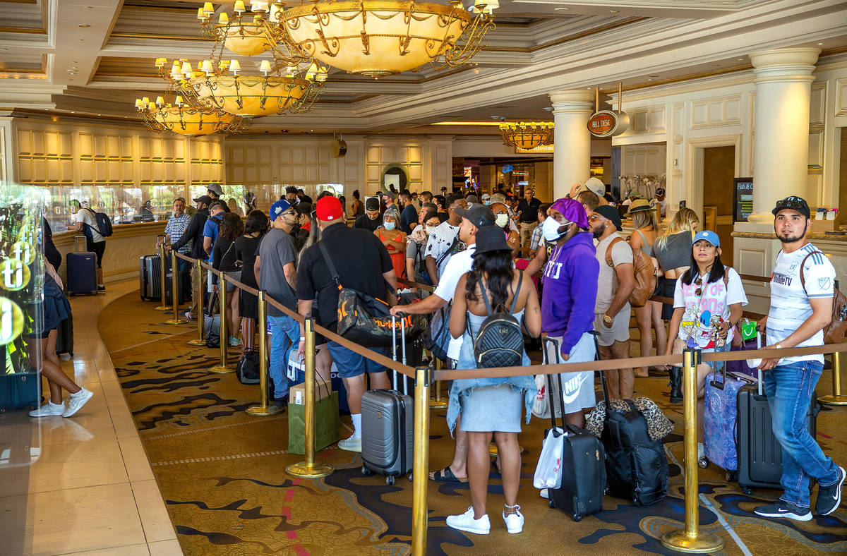 People stand in line to check in at Treasure Island, a large percentage not wearing mask, on Fr ...
