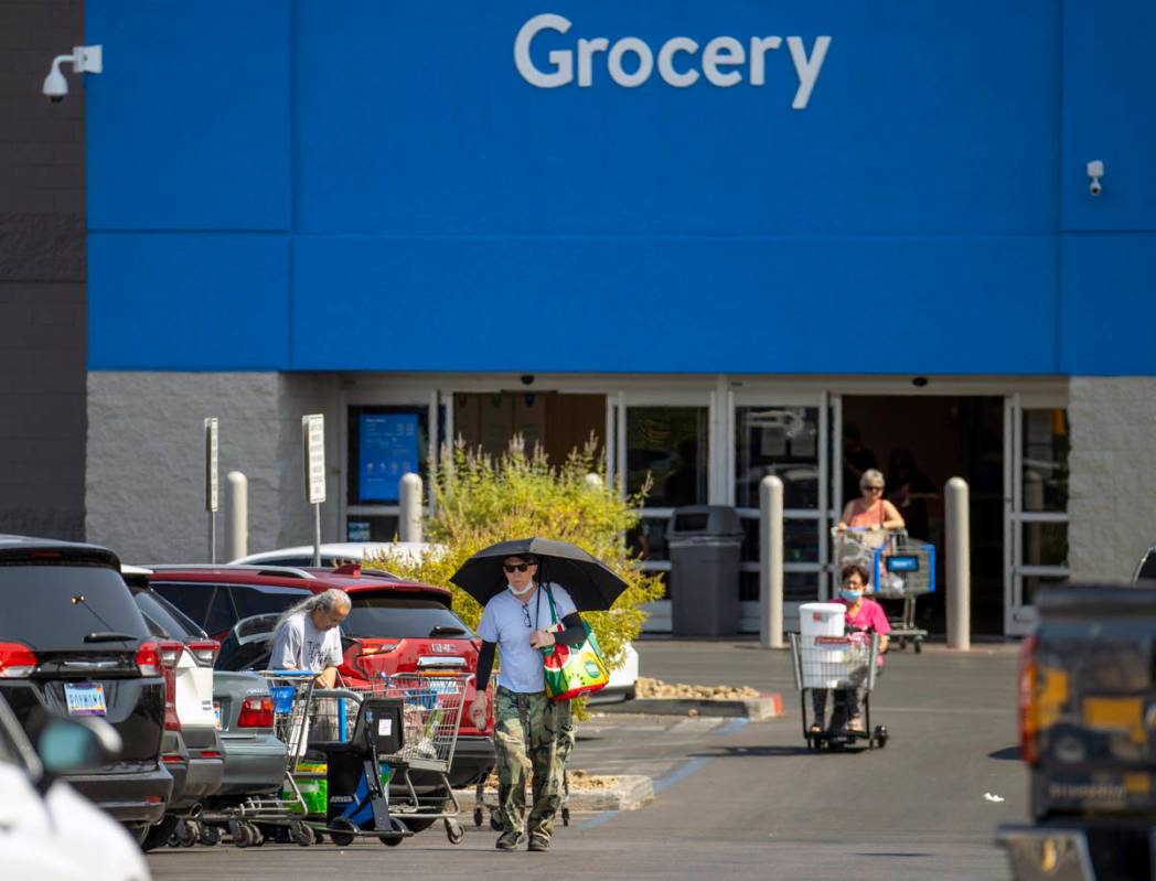 Shoppers make their way through a Walmart parking lot, most not wearing mask, on Friday, July 1 ...