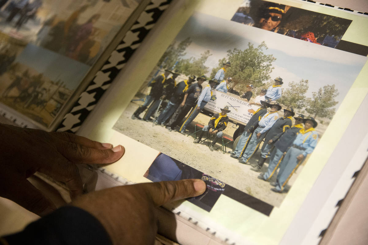 Mitchell Sayles, a member of the Buffalo Soldiers, pages through a scrapbook during an event fo ...