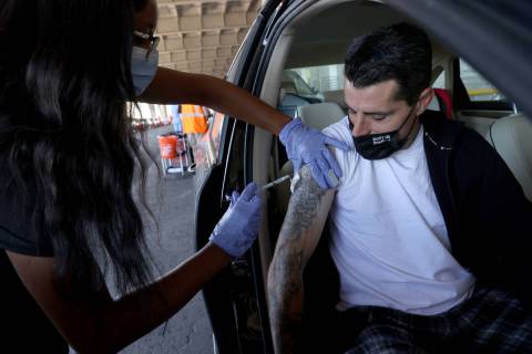 David Lotta of Las Vegas gets his shot from Destanee Sanders during a drive-thru COVID-19 vacci ...