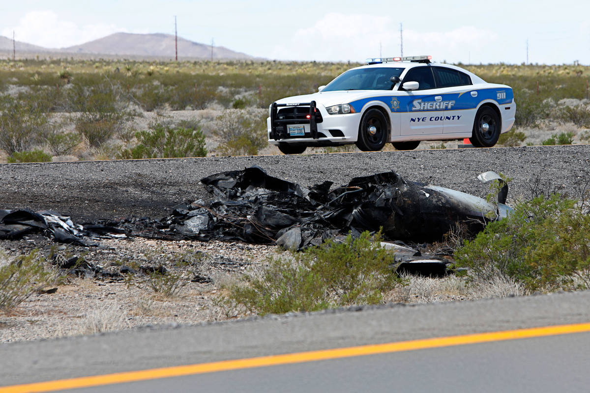 Law enforcement officers investigate a plane crash on U.S. Highway 95, around the Nye County bo ...