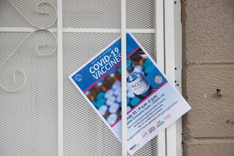 A COVID-19 vaccine information flyer placed on the door at an apartment complex by nonprofit vo ...