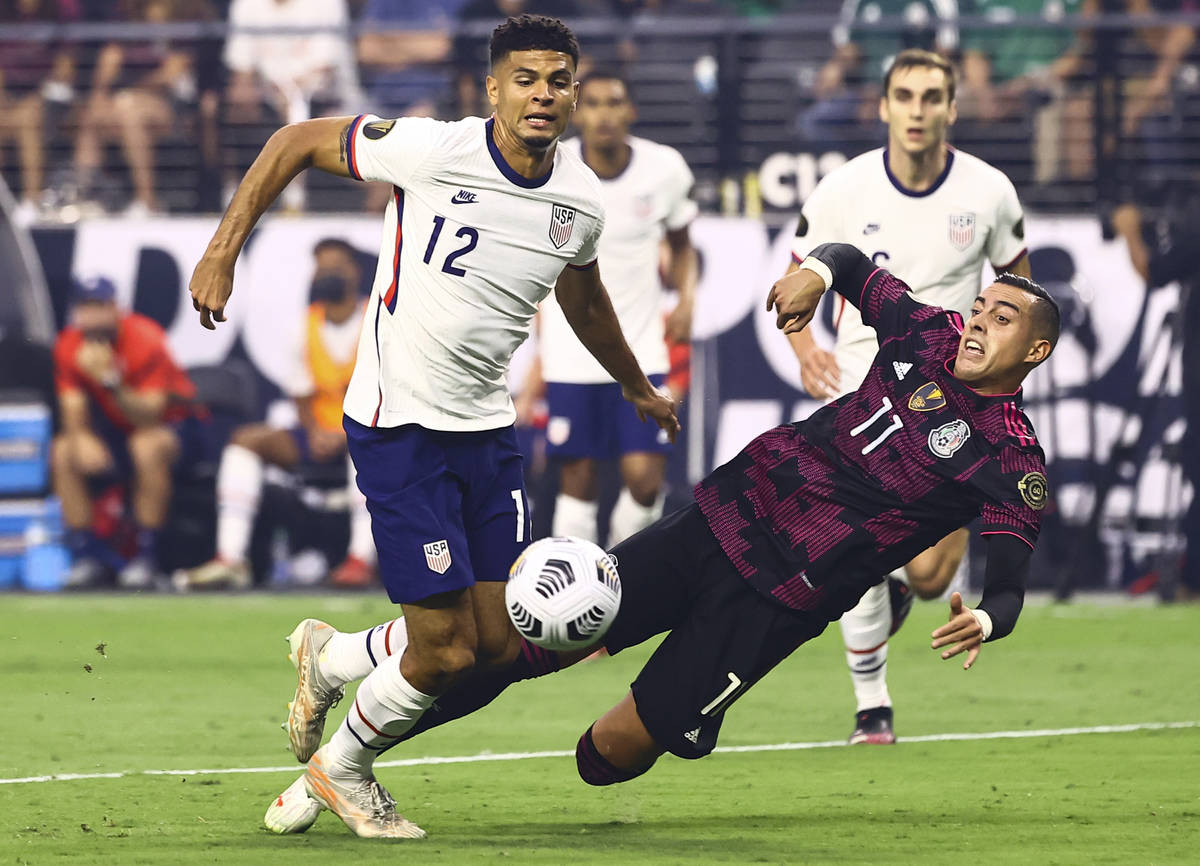 Mexico forward Rogelio Funes Mori (11) gets tripped up in front of United States defender Miles ...
