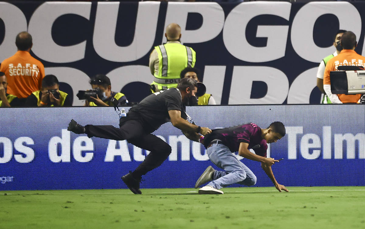A security guard chases down a soccer fan during the second half of the Concacaf Gold Cup final ...