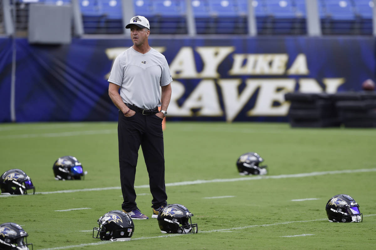 Baltimore Ravens coach John Harbaugh stands on the field before practice at NFL football traini ...