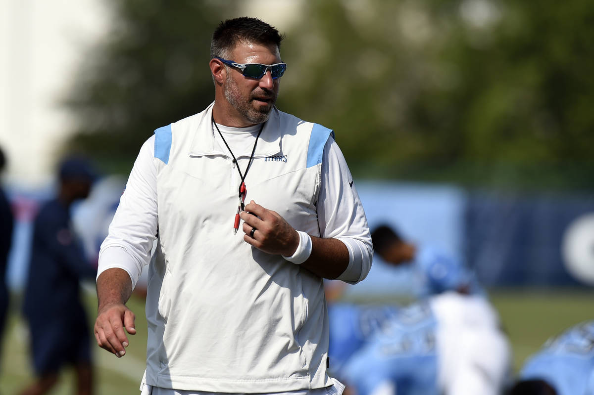 Tennessee Titans head coach Mike Vrabel watches his team warm up during NFL football training c ...